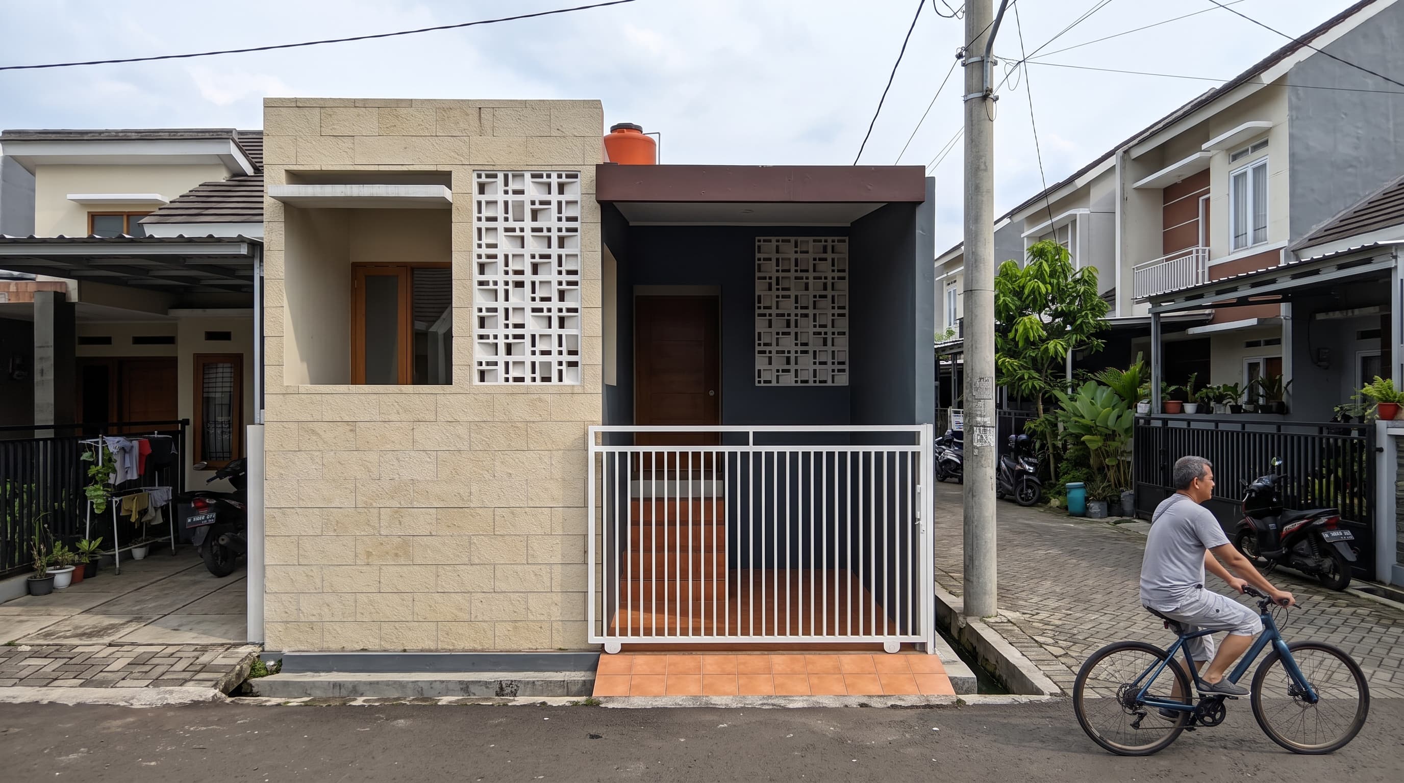 Rumah kompak modern dengan fasad batu alam paras krem dan roster di Mijen Semarang